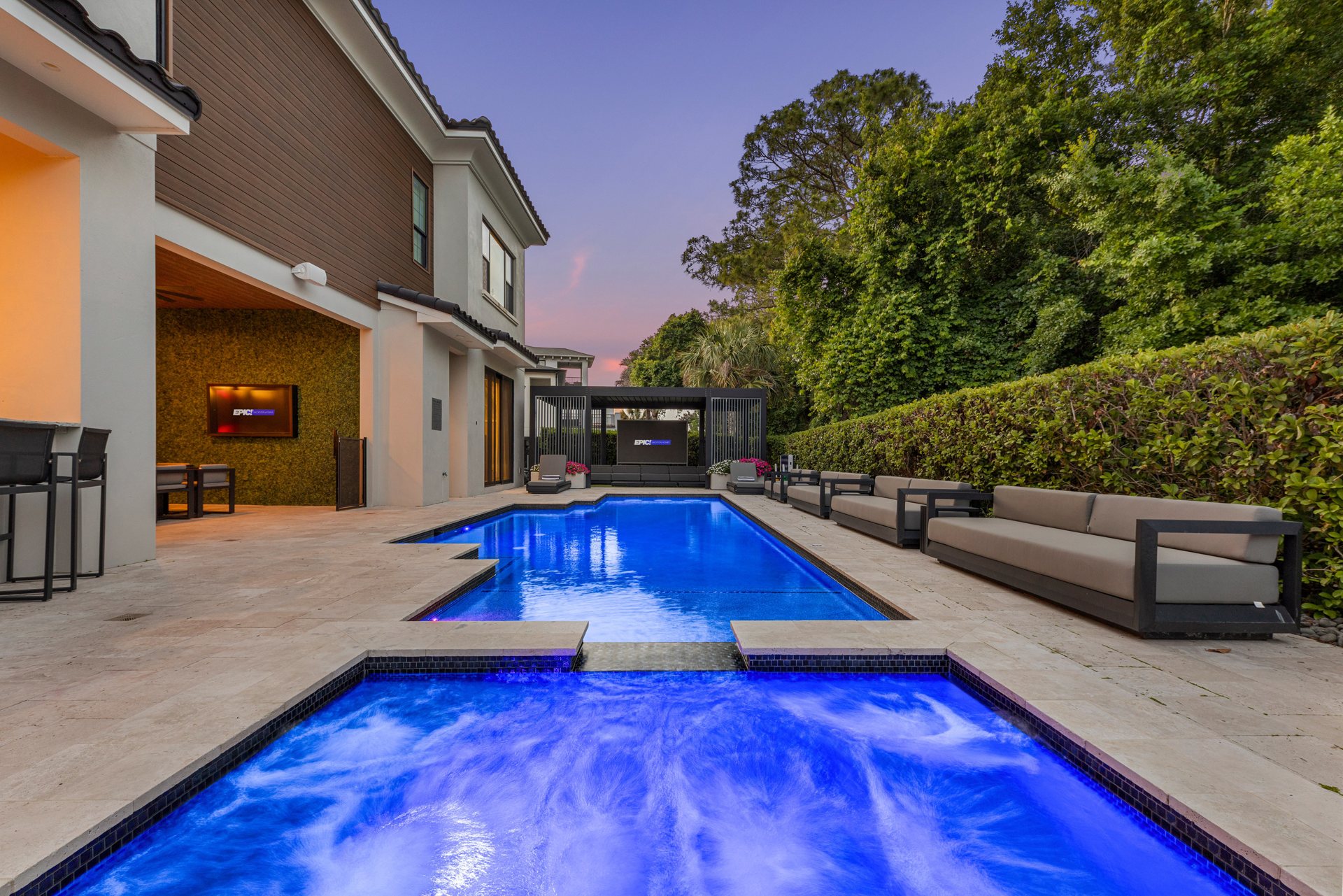 The 35-foot pool lit blue at dusk, with the outdoor video wall